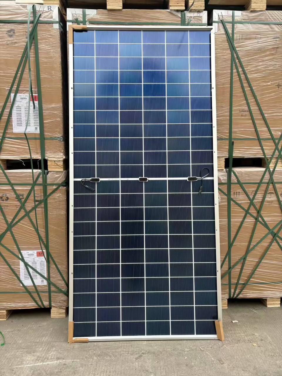 Rear of a framed solar panel with junction boxes and cables