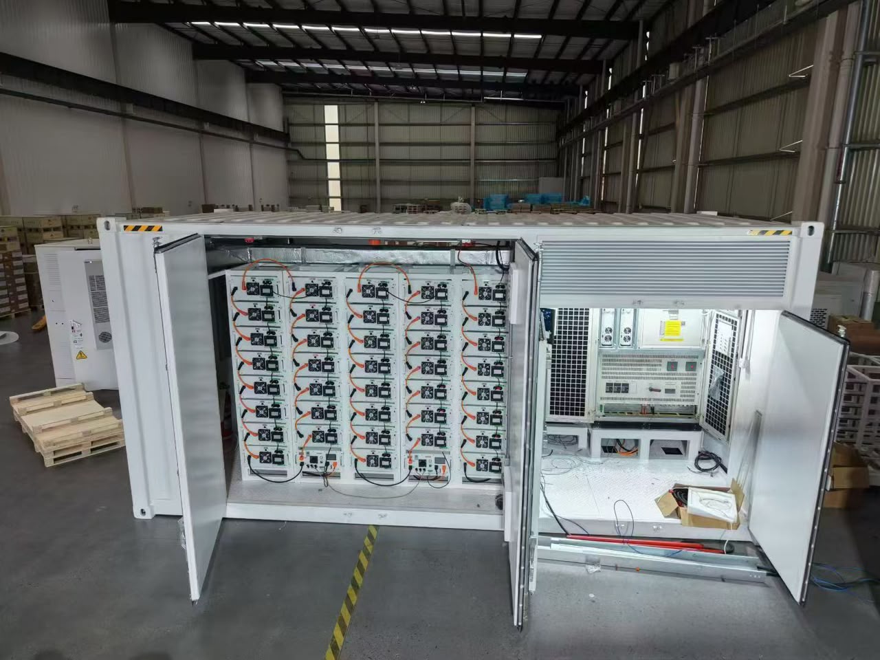 Open energy storage container showing battery racks and electrical equipment